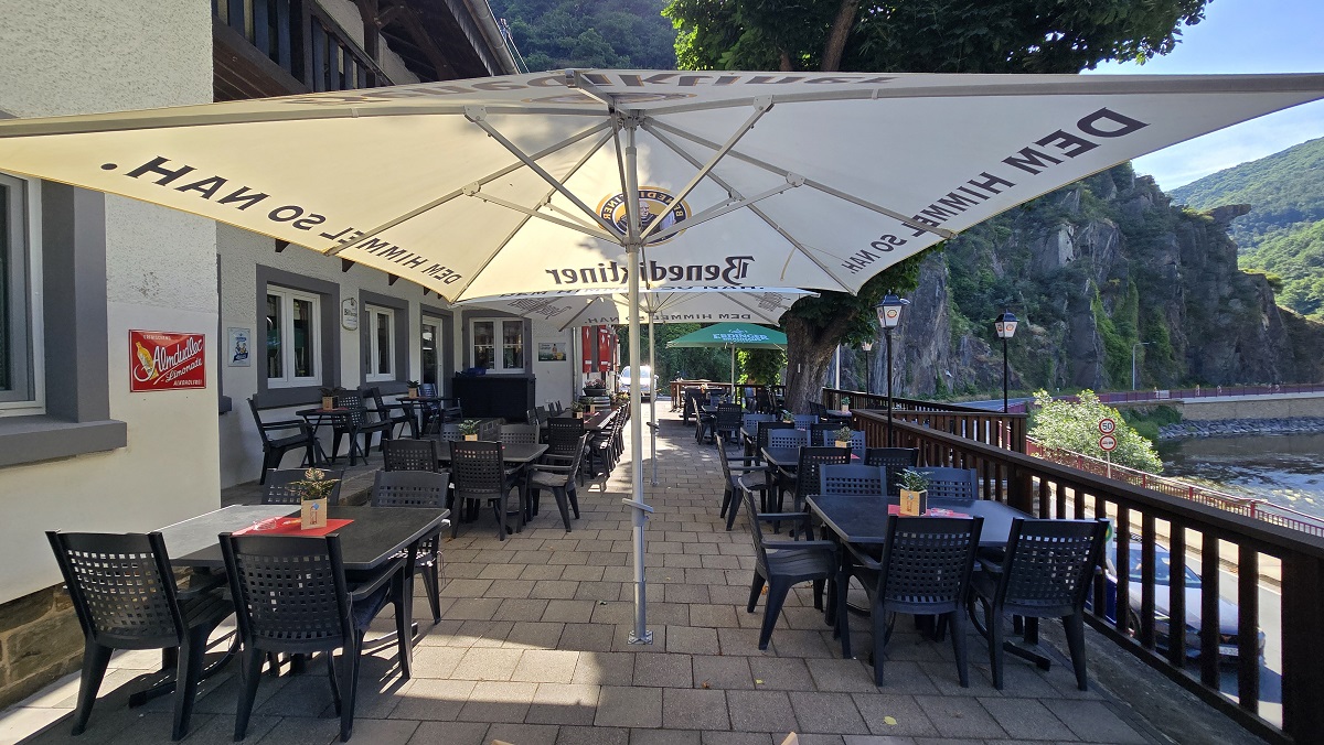 Gedeckte Tische unter Sonnenschirmen